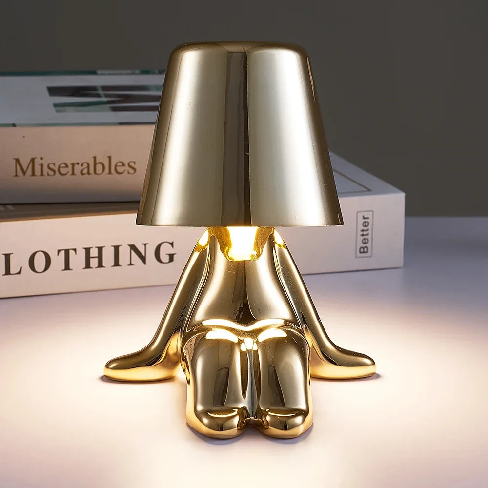 Designerska lampa stołowa LED siedzący człowiek z połyskującym wykończeniem