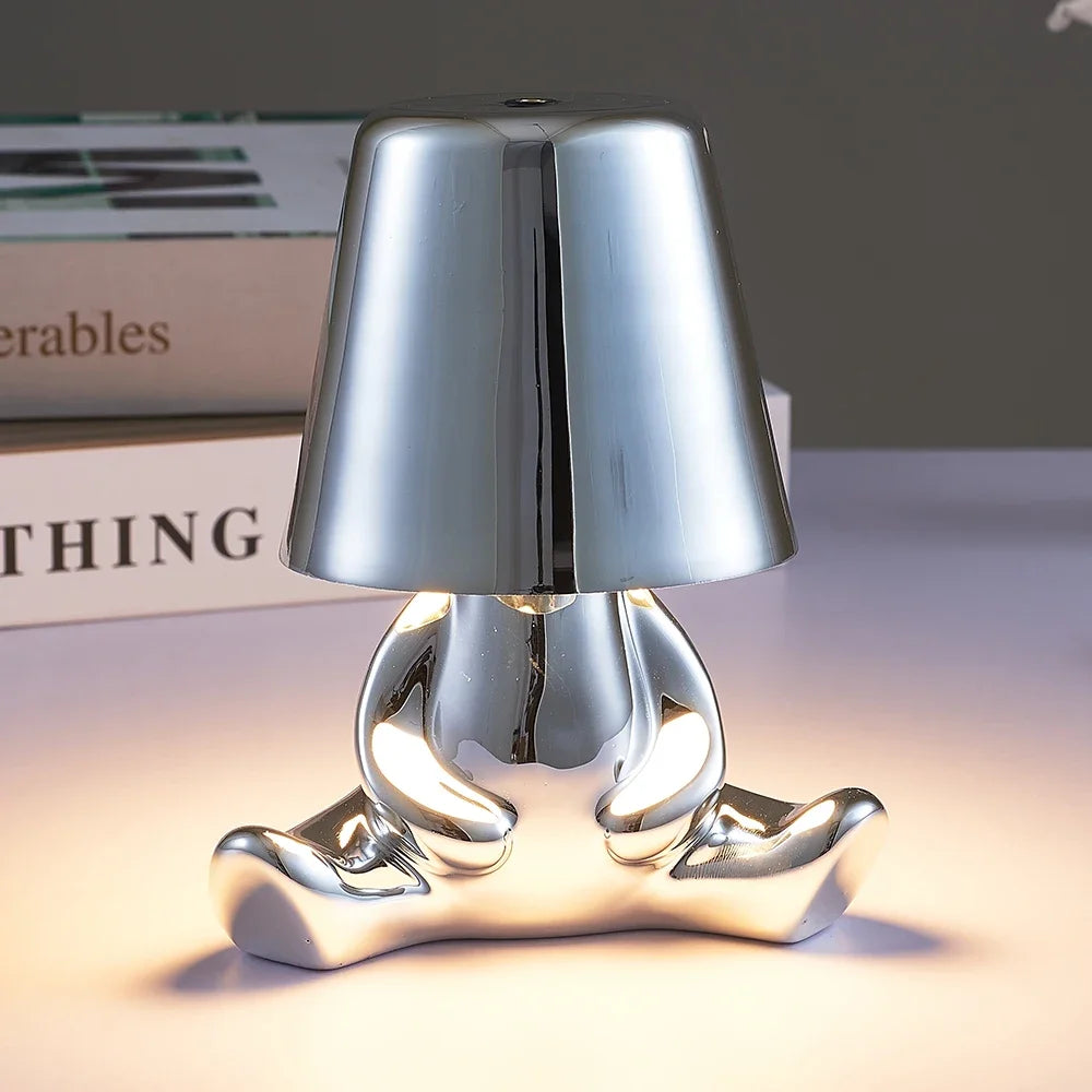 Designerska lampa stołowa LED siedzący człowiek z połyskującym wykończeniem