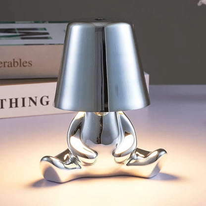 Designerska lampa stołowa LED siedzący człowiek z połyskującym wykończeniem