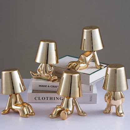 Designerska lampa stołowa LED siedzący człowiek z połyskującym wykończeniem