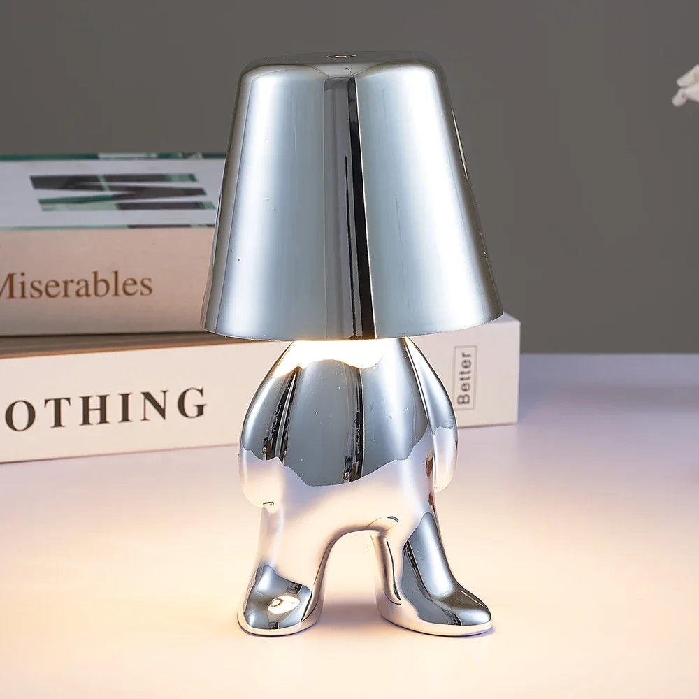 Designerska lampa stołowa LED siedzący człowiek z połyskującym wykończeniem