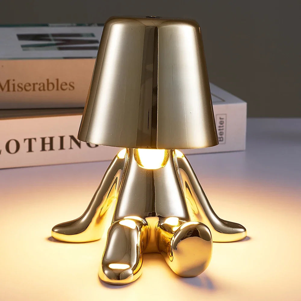 Designerska lampa stołowa LED siedzący człowiek z połyskującym wykończeniem