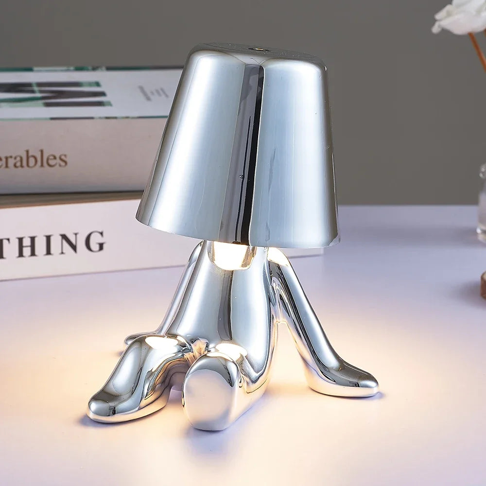 Designerska lampa stołowa LED siedzący człowiek z połyskującym wykończeniem