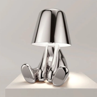 Designerska lampa stołowa LED siedzący człowiek z połyskującym wykończeniem